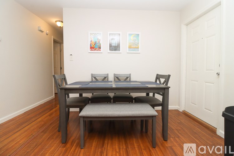 A dining table with four chairs and a bench in a room.