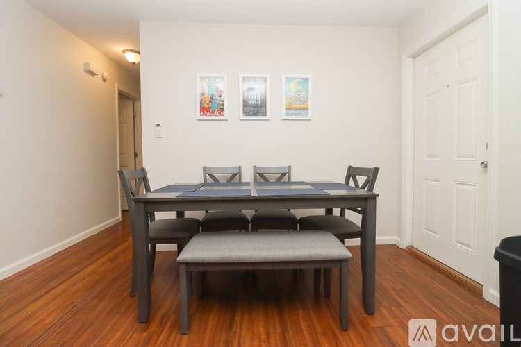 A dining table with four chairs and a bench in a room.