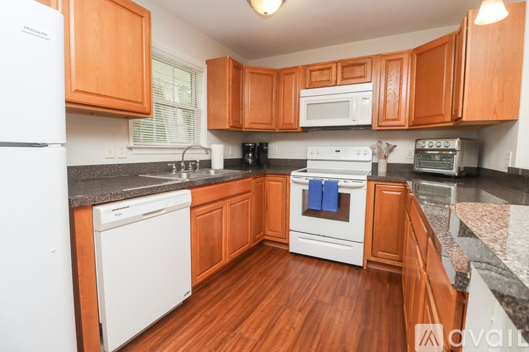 A kitchen with wooden cabinets and white appliances.