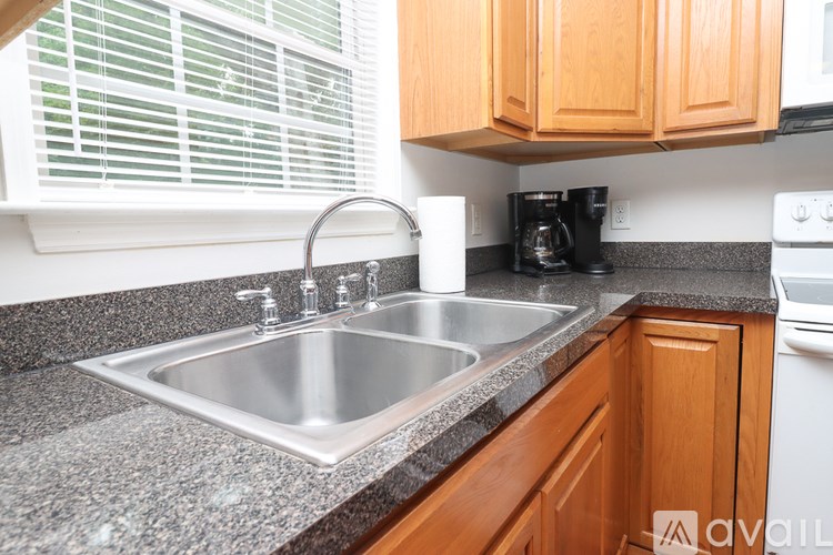 A kitchen with a sink and a stove top oven.
