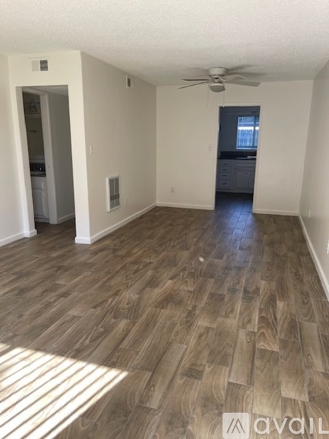 A room with wooden flooring and a ceiling fan.