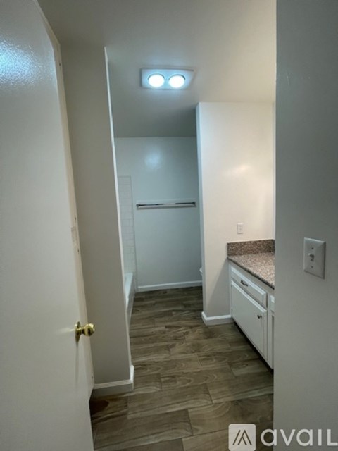 A small kitchen with a refrigerator and a drawer pulled out.