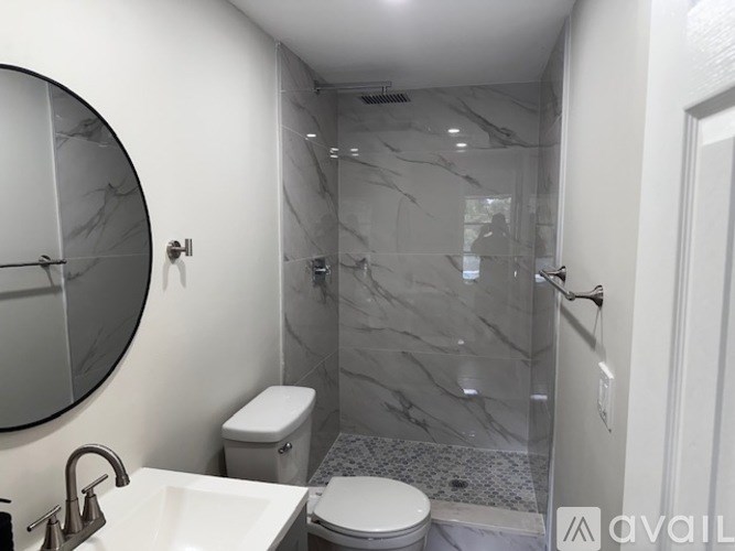 A bathroom with a marble shower and toilet.