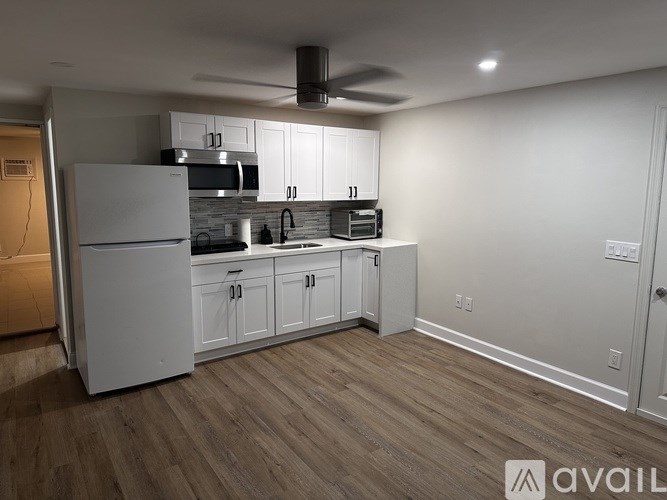 A room with a ceiling fan and wooden flooring.