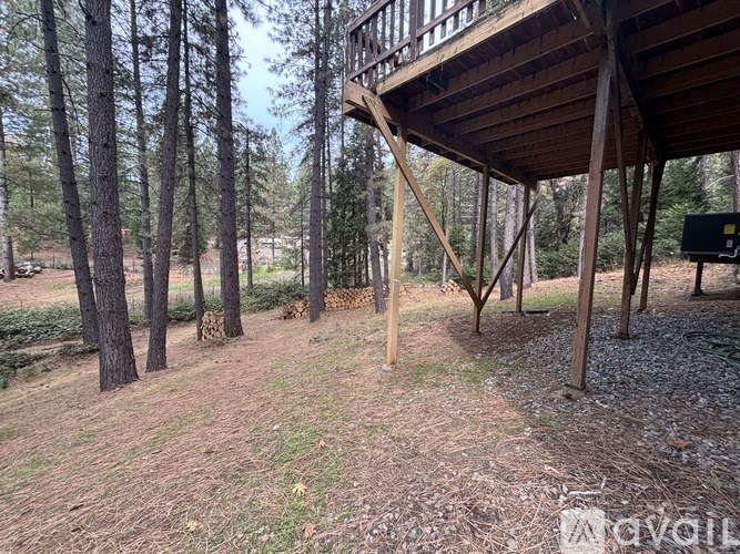 A wooden deck structure is surrounded by trees in a wooded area.
