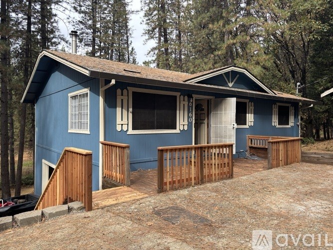 A blue house with a porch and a covered entrance.