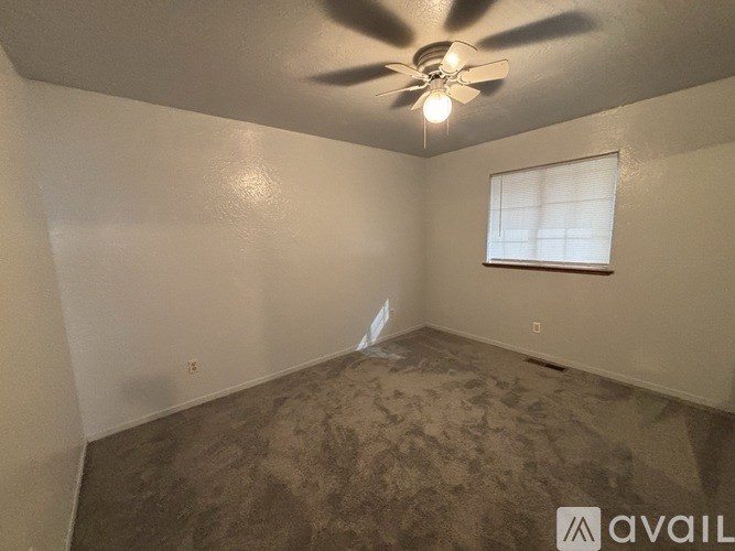 A room with a ceiling fan and a window.