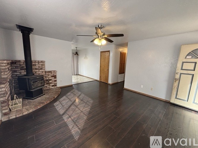 A living room with a fireplace and a ceiling fan.