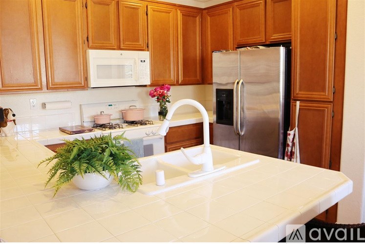 A kitchen with wooden cabinets and a white countertop.