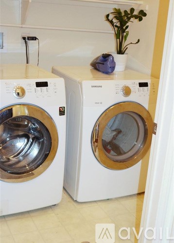 Two white front loading washing machines in a laundry room.