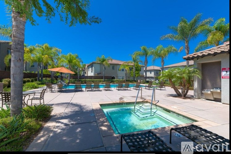 A pool surrounded by palm trees and a clear blue sky.