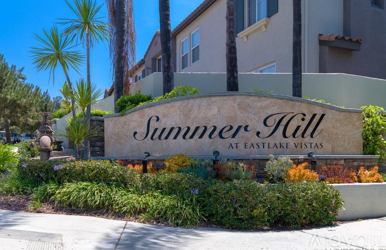 A sign that says "Summer Hill at Eastlake Vistas" is in front of a building.
