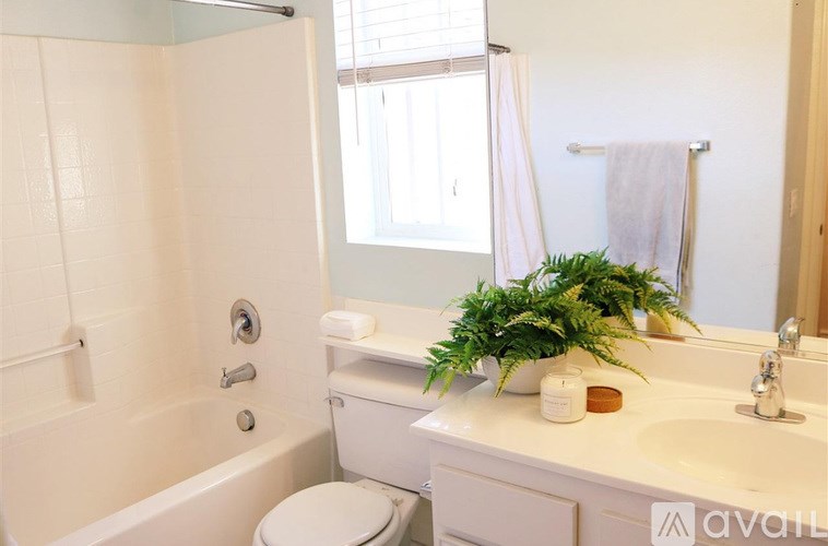 A bathroom with a white toilet, a white sink, and a white bathtub.