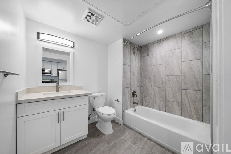 A bathroom with a white tub, sink, and toilet.