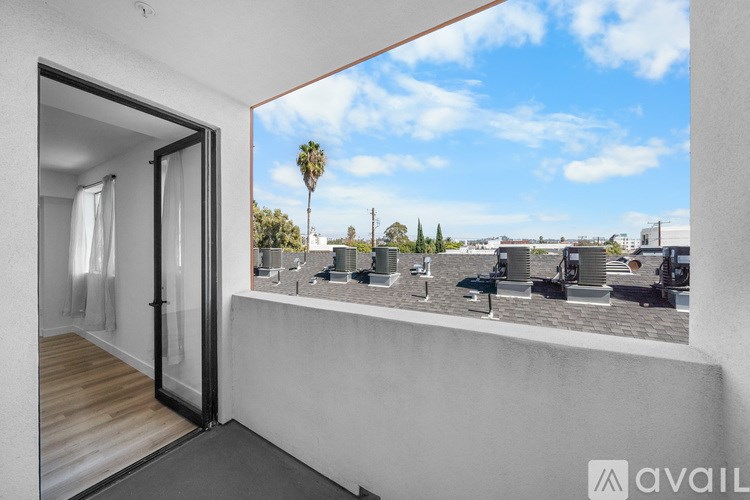 A balcony with a view of a cityscape and palm trees.
