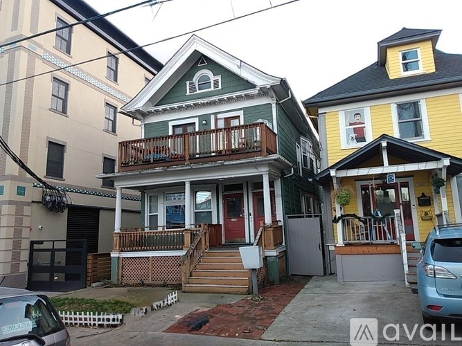 A house with a green front and a balcony.