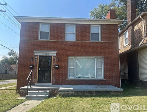 A red brick house with a black door and windows.