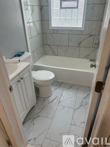 A bathroom with a toilet, sink, and bathtub.