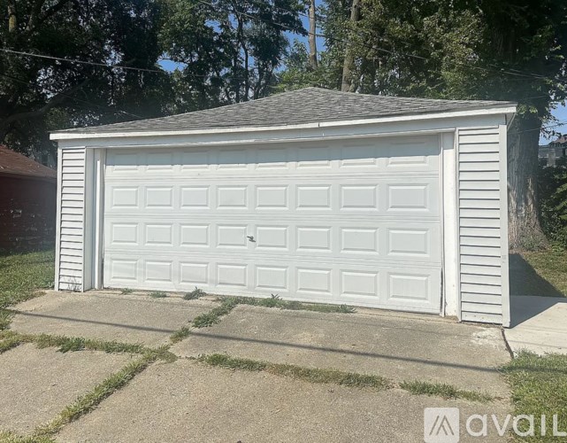 A white garage door is closed and has a small window on the right side.