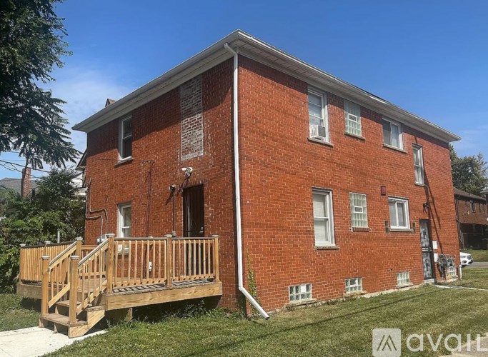 A red brick house with a wooden deck in front.