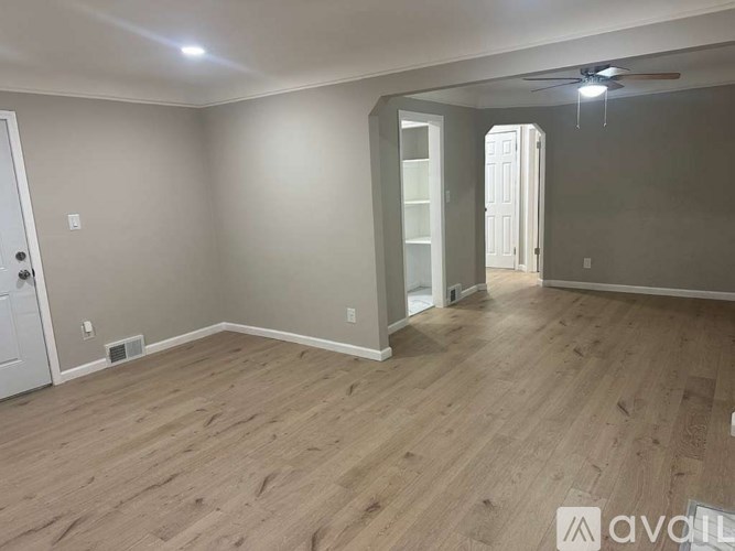 A room with wooden flooring and a ceiling fan.