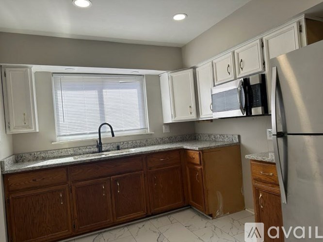 A kitchen with wooden cabinets and a granite countertop.