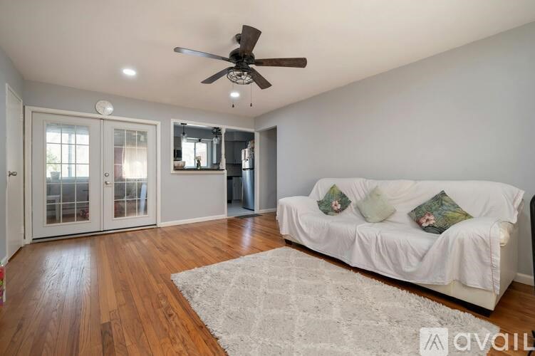 A living room with a white couch and a ceiling fan.
