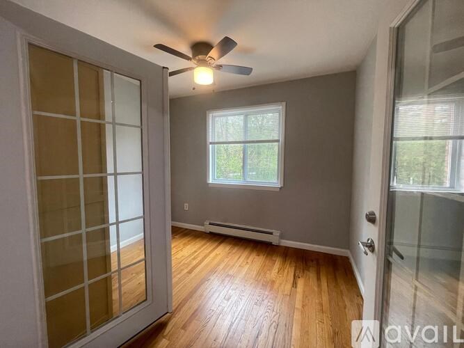 A room with a ceiling fan and a window.