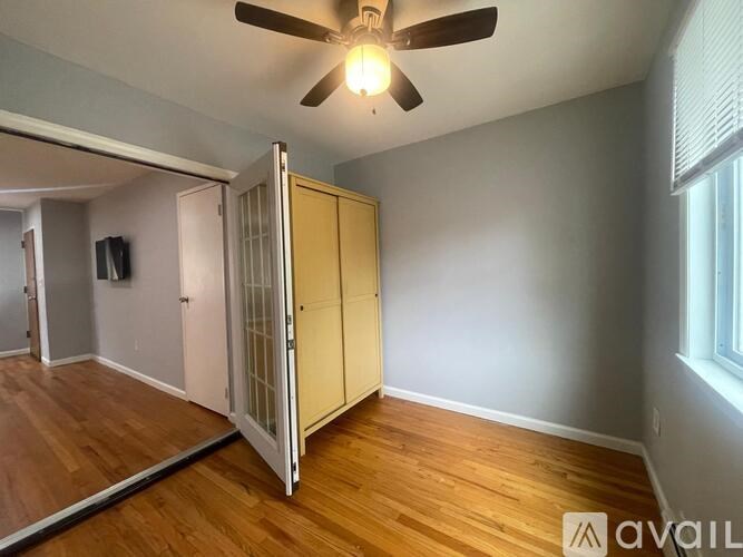 A room with a ceiling fan and a wooden floor.