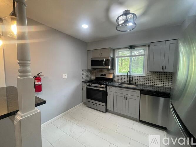 A kitchen with white cabinets and a black countertop.