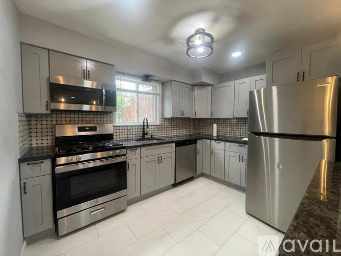 A kitchen with a stainless steel refrigerator, oven, and microwave.