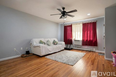 A living room with a white couch and a ceiling fan.
