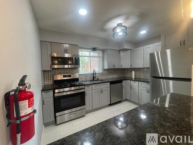 A kitchen with a red fire extinguisher on the left side.