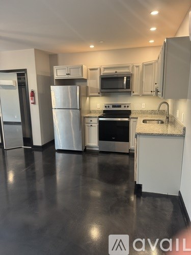A kitchen with a black floor and white appliances.