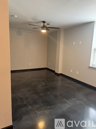 A room with a ceiling fan and a window with blinds.