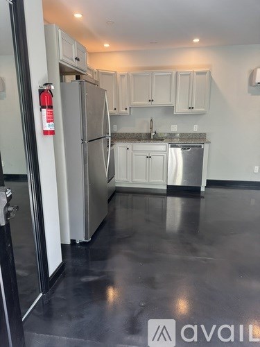 A kitchen with a stainless steel refrigerator, dishwasher, and oven.