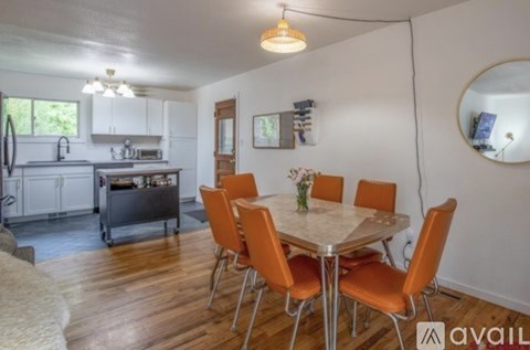 A kitchen with a dining table and chairs.