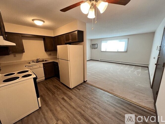 A kitchen with a white refrigerator, stove, and cabinets.