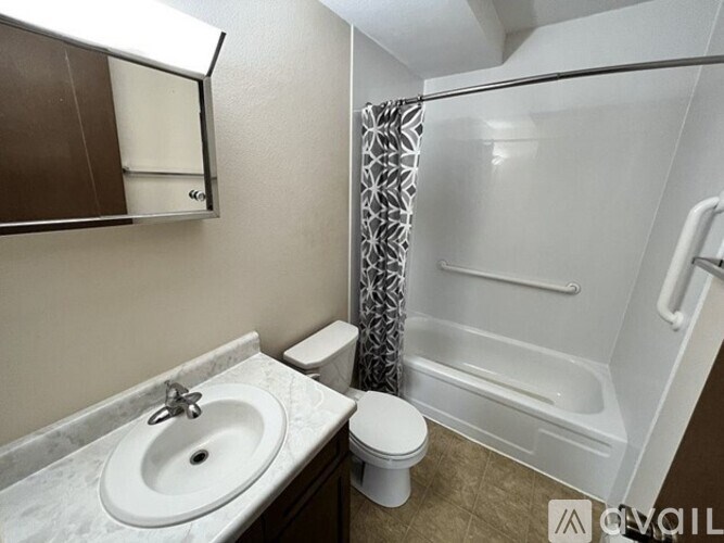 A white sink is on a marble countertop in a small bathroom.