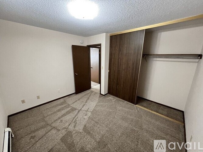 A room with a carpeted floor and a wooden door.