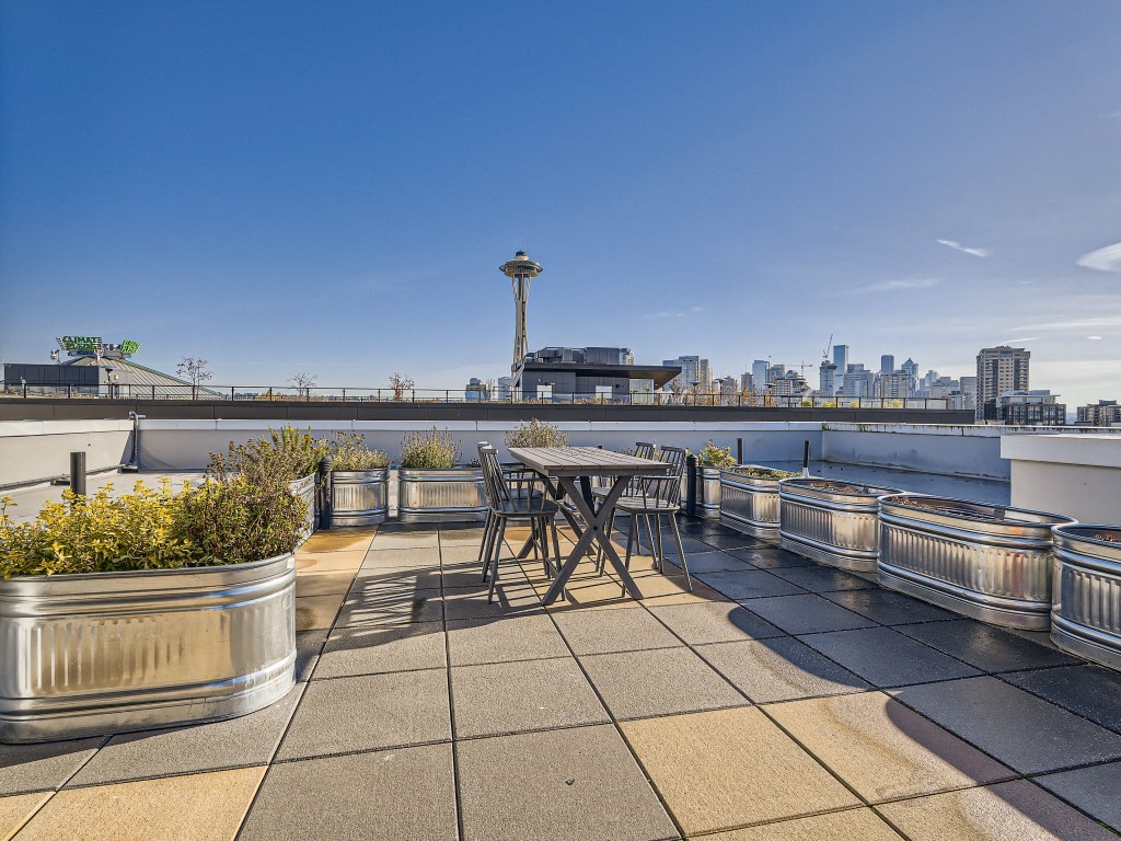 a table and chairs on a roof terrace with a view of the city