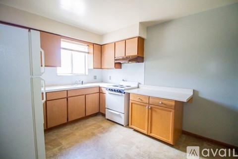 A kitchen with wooden cabinets and a white refrigerator.