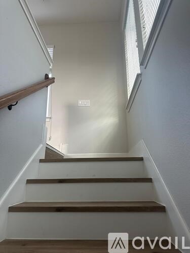 A staircase with wooden steps and white walls.