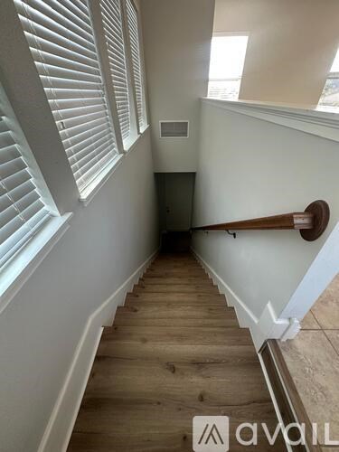 A staircase with wooden steps and a white railing.
