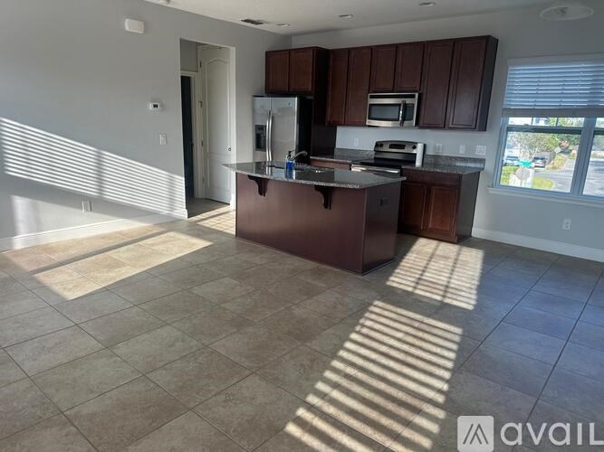 A kitchen with brown cabinets and a tiled floor.