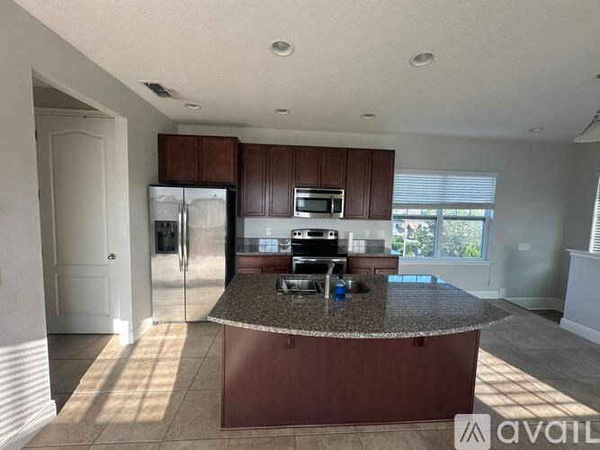 A kitchen with brown cabinets and a granite countertop.