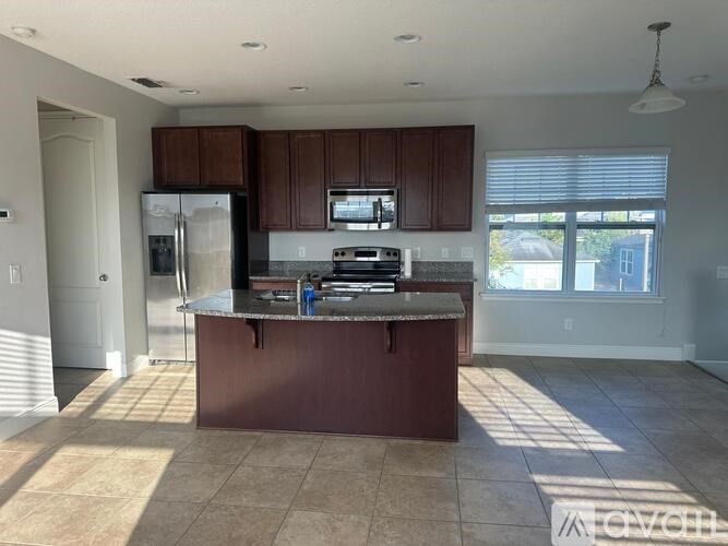 A kitchen with brown cabinets and a brown island.