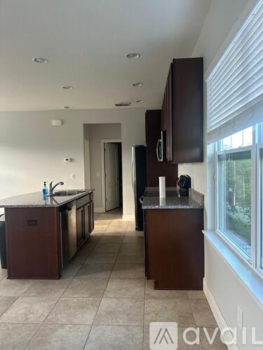 A kitchen with brown cabinets and a tiled floor.