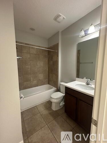 A bathroom with a toilet, sink, and bathtub.