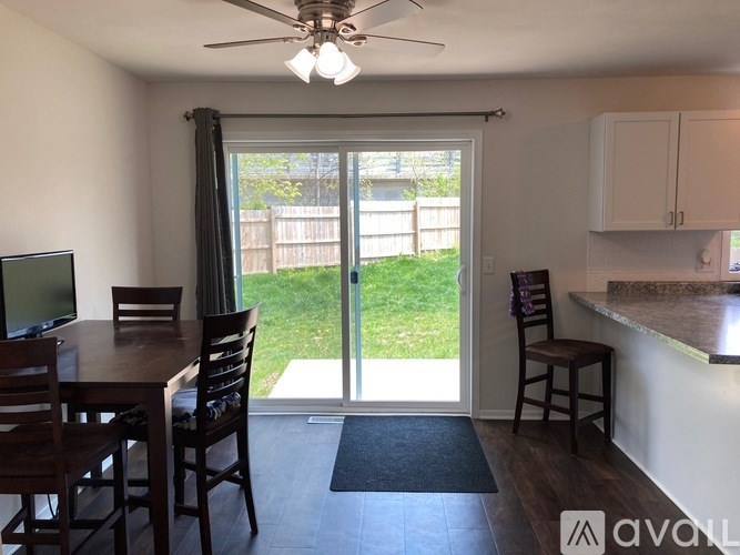A dining room with a table, chairs, and a ceiling fan.